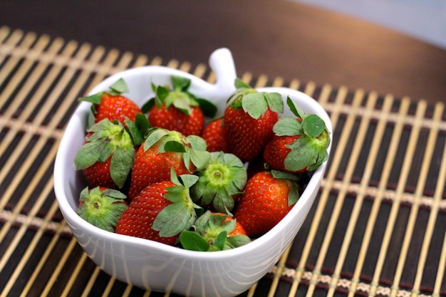 Vista de ángulo alto de las fresas en un cuenco en la mesa