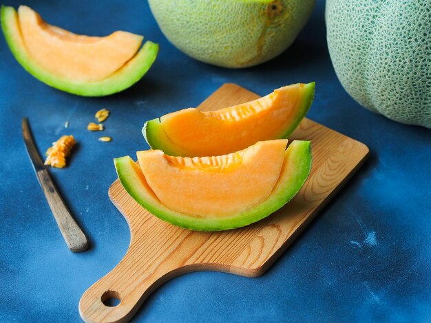 Foto vista de ángulo alto de las frutas de melón en la tabla de corte