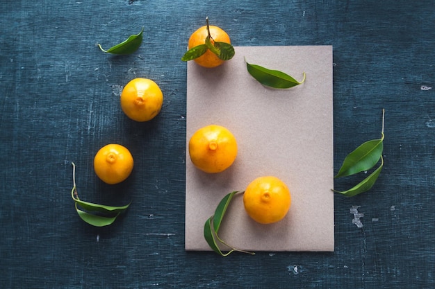 Foto vista de ángulo alto de frutas de naranja y cartón en la mesa