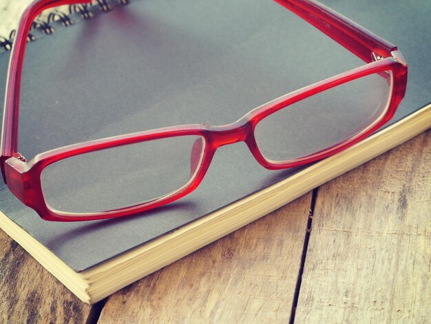 Foto vista de ángulo alto de gafas con diario en una mesa de madera