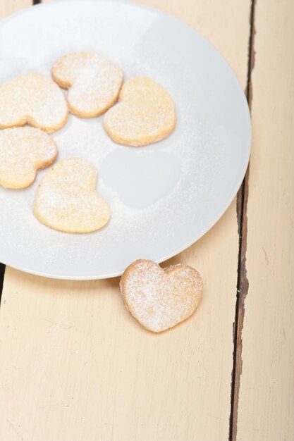 Foto vista de ángulo alto de galletas en forma de corazón en el plato sobre la mesa