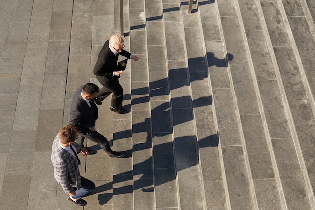 Vista de ángulo alto de gente de negocios subiendo las escaleras juntos en la ciudad