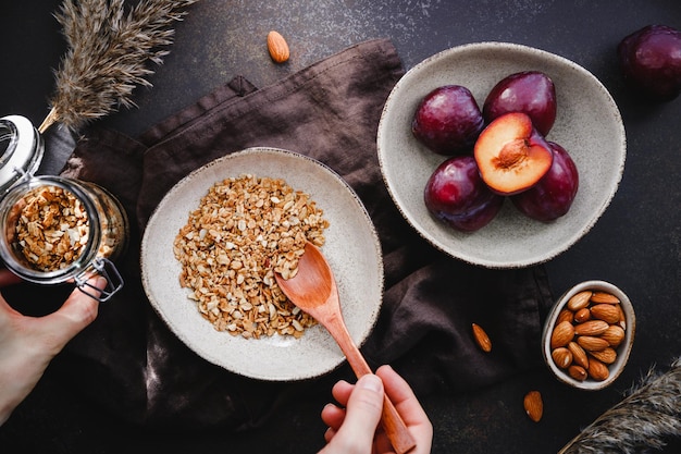 Vista de ángulo alto de granola matutina con almendras y ciruelas en rodajas Desayuno de energía saludable