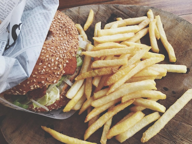 Foto vista de ángulo alto de la hamburguesa y las papas fritas en la mesa