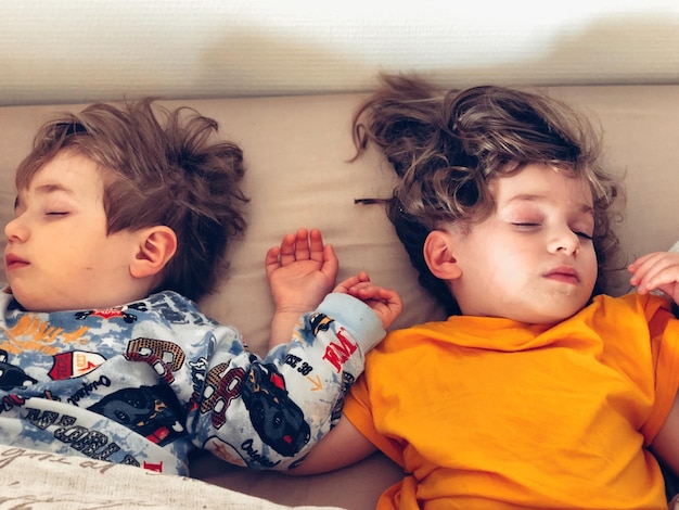 Vista de ángulo alto de los hermanos durmiendo en la cama en casa