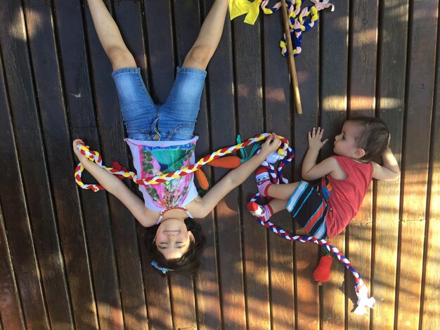 Foto vista de ángulo alto de hermanos tendidos en el suelo