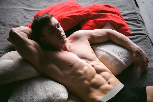 Foto vista de ángulo alto de un hombre sin camisa acostado en la cama en casa