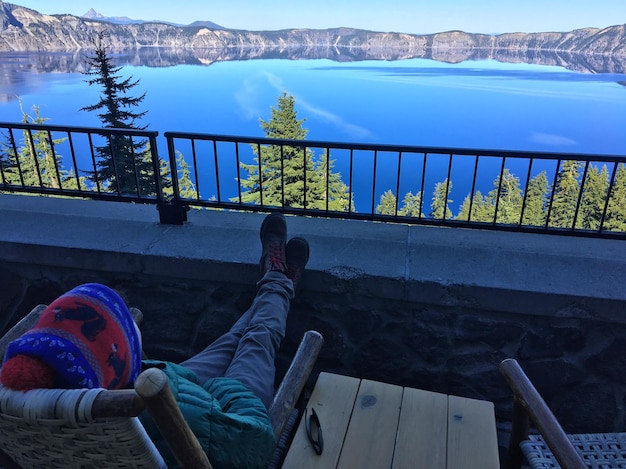 Foto vista de ángulo alto de un hombre mirando el lago mientras está sentado en una silla