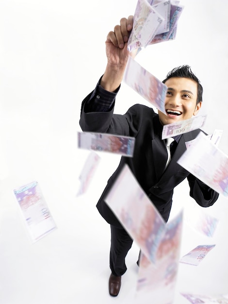 Foto vista de ángulo alto de un hombre de negocios sosteniendo papel moneda sobre un fondo blanco