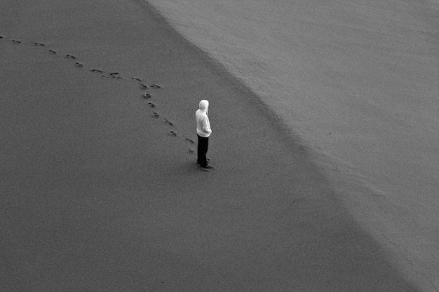 Foto vista de ángulo alto de un hombre de pie en la playa