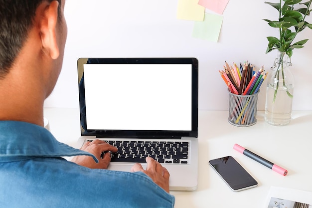 Vista de ángulo alto de un hombre usando una computadora portátil en el escritorio