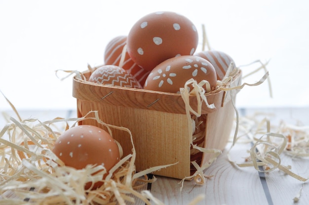 Vista de ángulo alto de huevos de Pascua en la canasta sobre la mesa