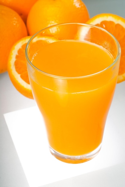 Vista de ángulo alto del jugo de naranja en el vaso de beber en la mesa