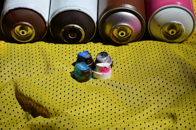 Foto vista de ángulo alto de latas de aerosol abandonadas en textil amarillo