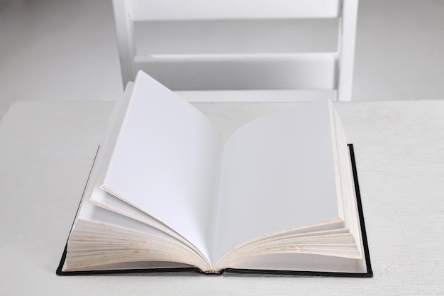 Vista de ángulo alto del libro abierto en la mesa contra un fondo gris