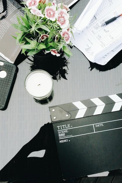 Vista de ángulo alto de la luz del té con la película y las flores en la mesa