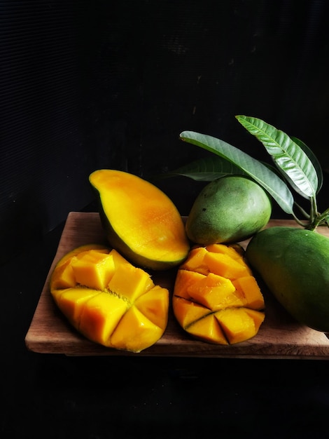 Foto vista de ángulo alto de mangos en la mesa contra un fondo negro