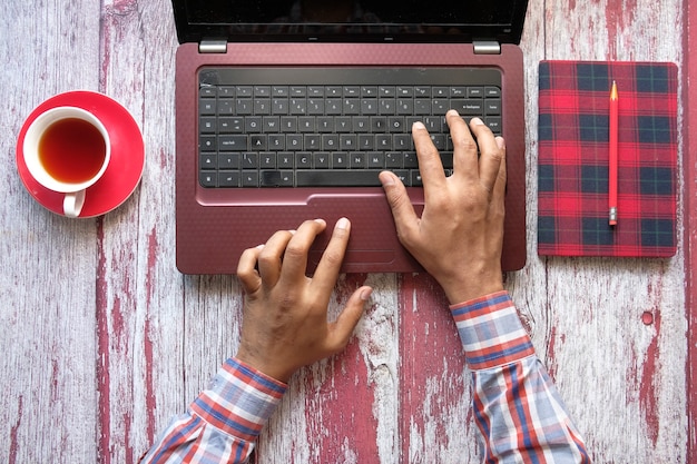 Vista de ángulo alto de la mano de la persona escribiendo en el teclado