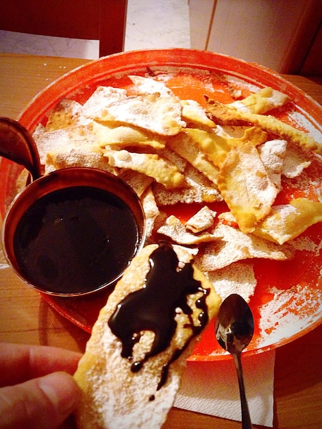 Foto vista de ángulo alto de la mano sosteniendo la comida en la mesa