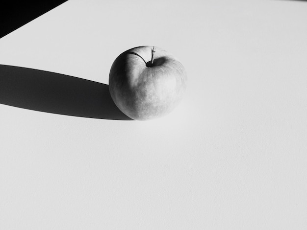 Foto vista de ángulo alto de la manzana con sombra en la mesa