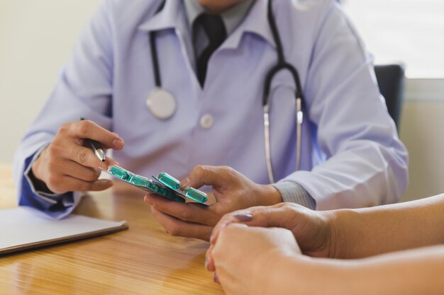 Foto vista de ángulo alto del médico dando la medicina al paciente en la mesa