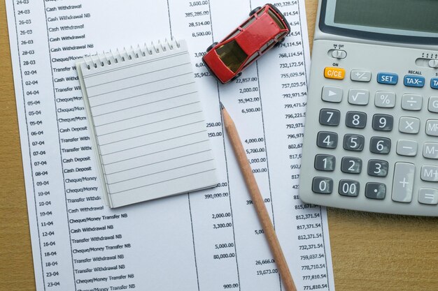 Vista de ángulo alto de un modelo de coche con calculadora por documento en la mesa