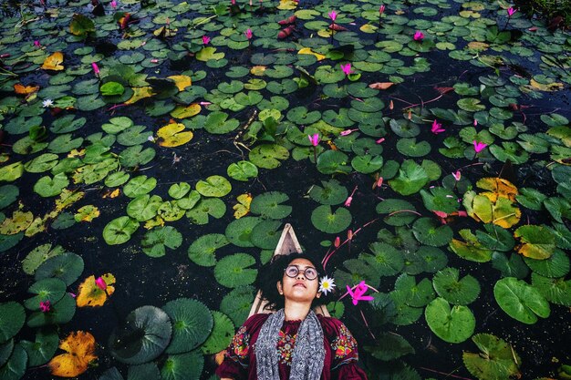 Foto vista de ángulo alto de una mujer acostada en un bote en el lago