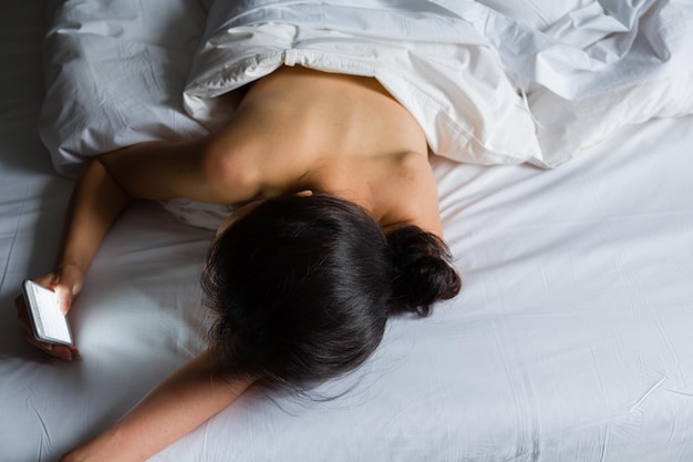 Vista de ángulo alto de una mujer acostada en la cama