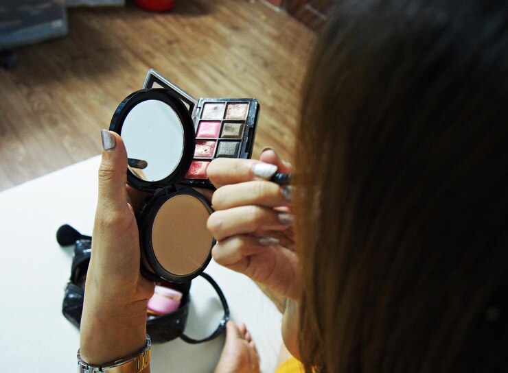 Foto vista de ángulo alto de una mujer aplicando productos de belleza en la mesa