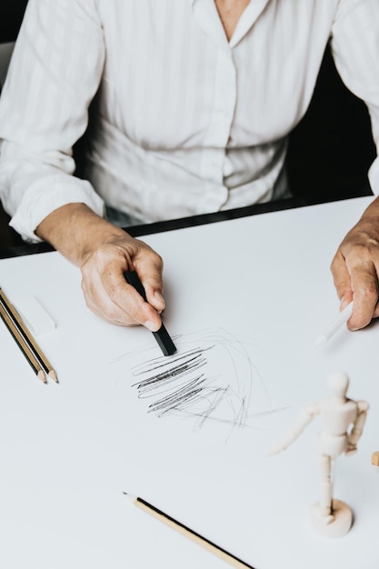 Vista de ángulo alto de una mujer caucásica senior dibujar bocetos en estudio. Concepto de creatividad, educación y personas, funciones cognitivas reloj dibujo prueba de autoevaluación en casa con resultados positivos