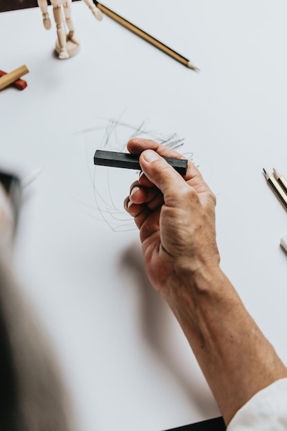 Vista de ángulo alto de una mujer caucásica senior dibujar bocetos en estudio. Concepto de creatividad, educación y personas, funciones cognitivas reloj dibujo prueba de autoevaluación en casa con resultados positivos