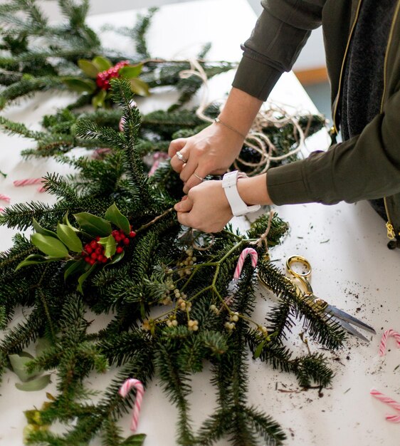 Vista de ángulo alto de una mujer decorando el árbol de Navidad en la mesa