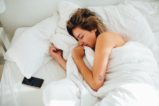 Vista de ángulo alto de una mujer durmiendo en la cama