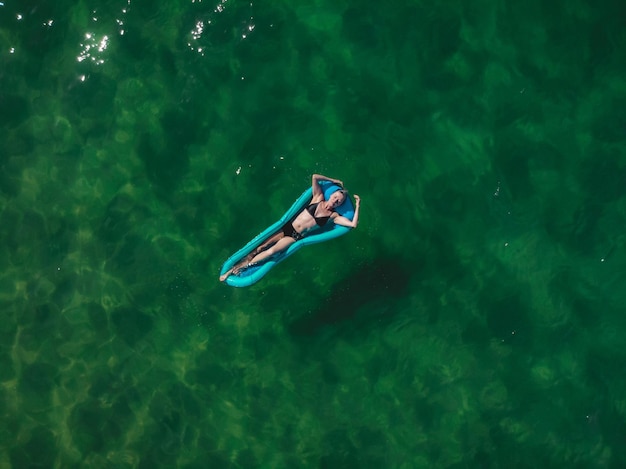 Foto vista de ángulo alto de una mujer flotando en el agua