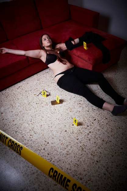 Foto vista de ángulo alto de una mujer joven muerta tendida en el suelo en casa
