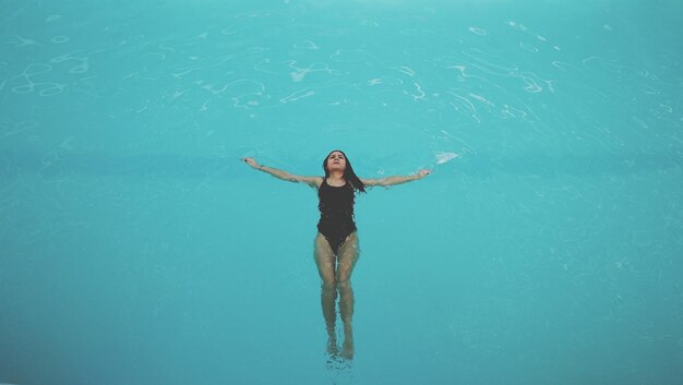 Foto vista de ángulo alto de una mujer joven nadando en el mar