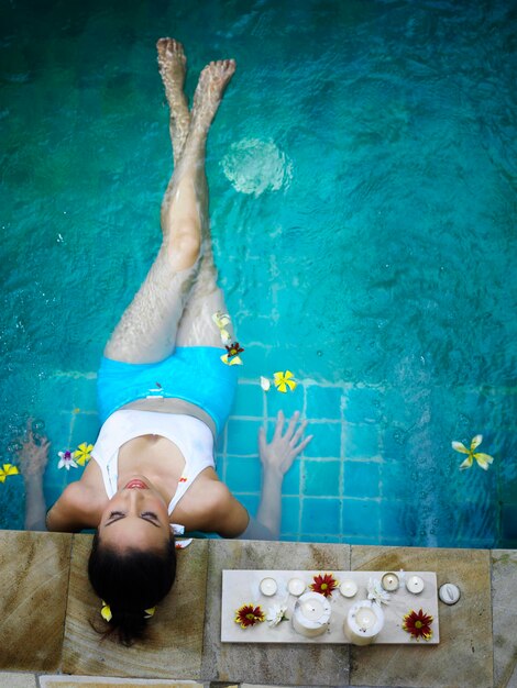 Foto vista de ángulo alto de una mujer joven relajándose en la piscina