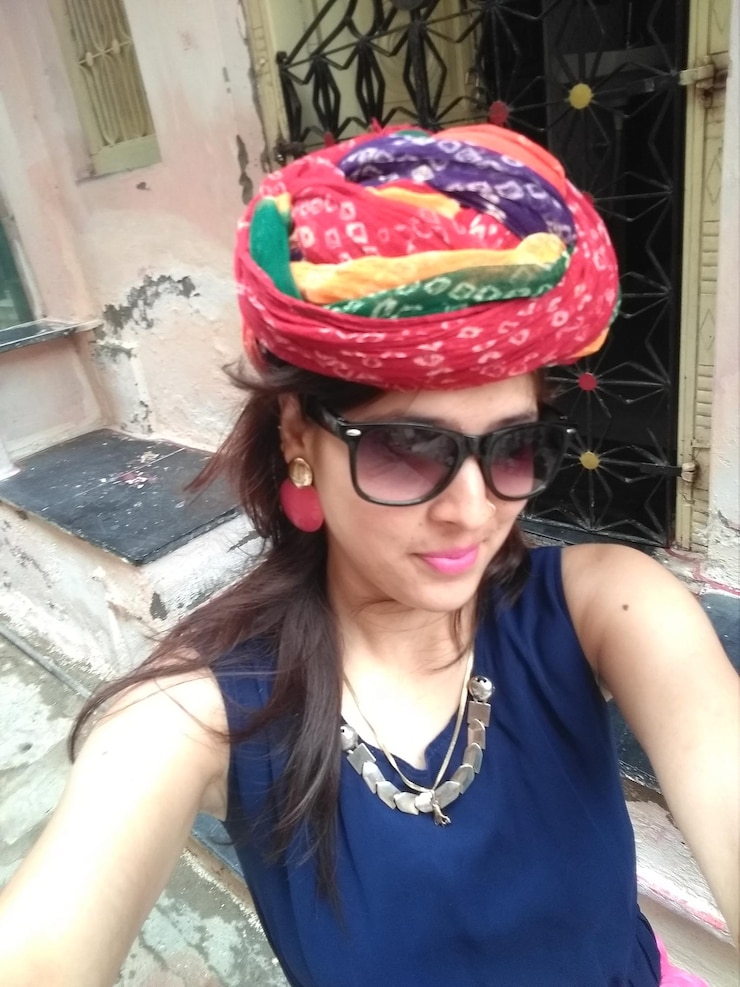 Foto vista de ángulo alto de una mujer joven con turbante contra la casa