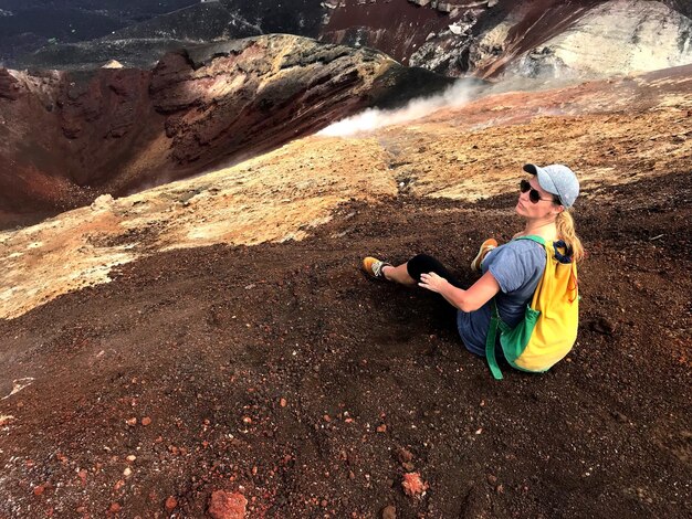 Foto vista de ángulo alto de una mujer madura sentada en la montaña