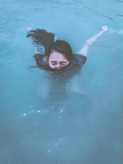 Vista de ángulo alto de una mujer nadando en la piscina