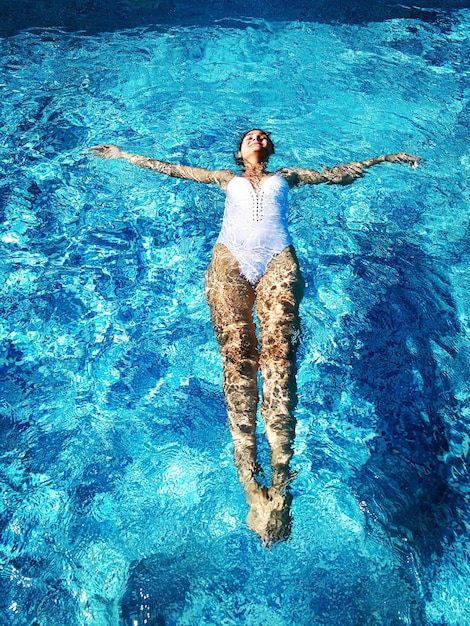 Foto vista de ángulo alto de una mujer nadando en la piscina