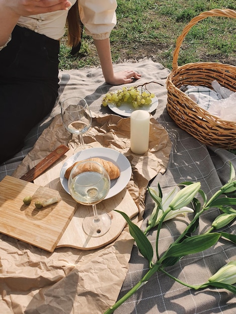 Vista de ángulo alto de una mujer de pie junto a una canasta de picnic de mimbre en la mesa
