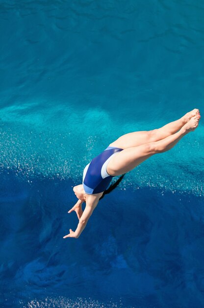 Foto vista de ángulo alto de una mujer saltando en la piscina