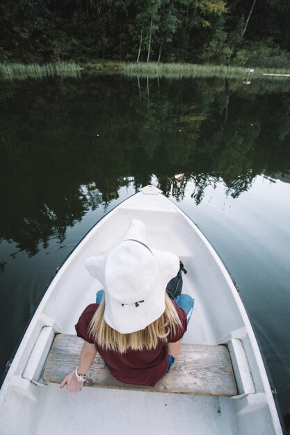 Foto vista de ángulo alto de una mujer sentada en un barco en el lago