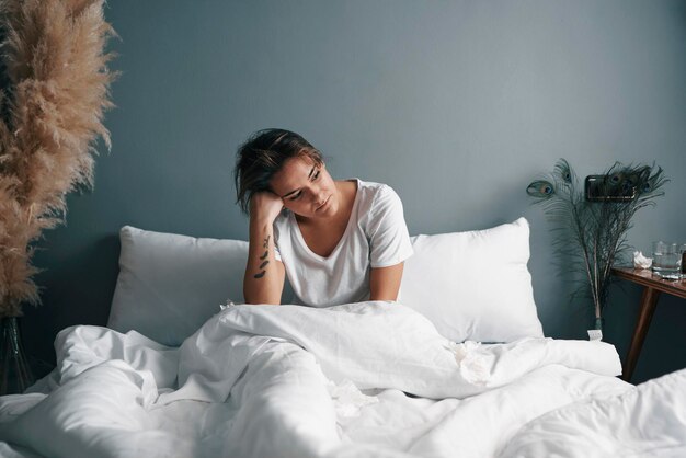 Foto vista de ángulo alto de una mujer sentada en la cama en casa