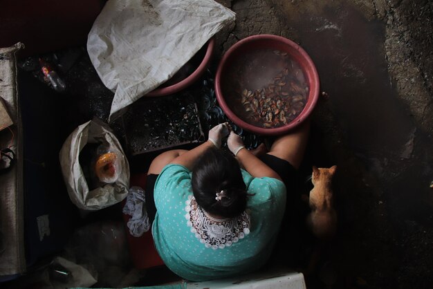 Vista de ángulo alto de una mujer sentada en un contenedor