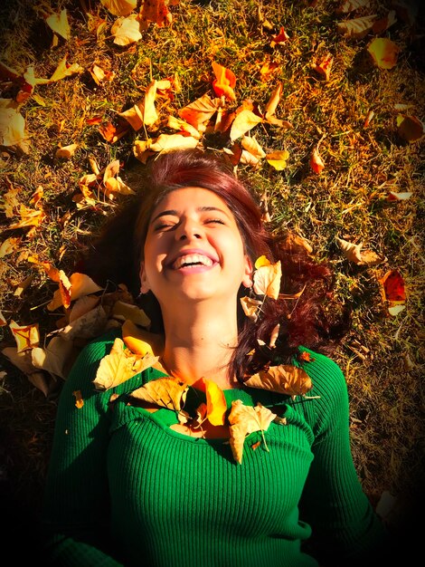 Foto vista de ángulo alto de una mujer sonriente acostada en el campo