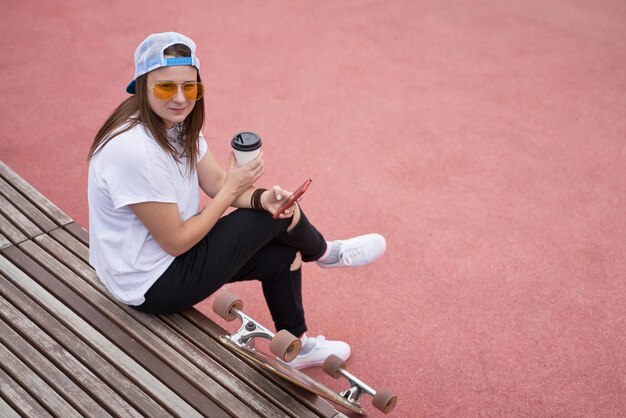 Foto vista de ángulo alto de una mujer sosteniendo café mientras está sentada al aire libre