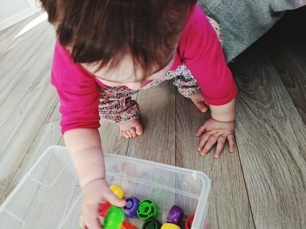 Foto vista de ángulo alto de una niña jugando con juguetes en el suelo