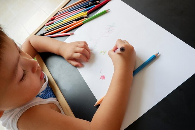 Vista de ángulo alto de un niño dibujando en papel